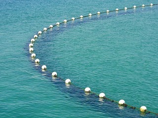 Submerged shark net with buoys in water background