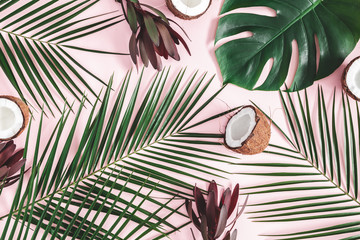 Summer composition. Tropical palm leaves, coconut, flowers on pastel pink background. Summer...