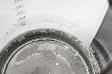 Limescale at the bottom of kettle - hard water concept