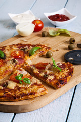 Slices of pizza with bacon, olives and tomatoes