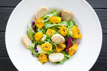 Tasty vegetarian salad with pumpkin and greens.