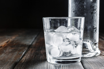 Vodka in shot glasses on rustic wood background