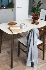 Breakfast time and kitchen place with coffee mug on wooden desk with opened book 