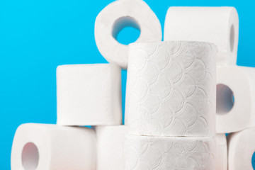 Toilet paper rolls stacked against blue background