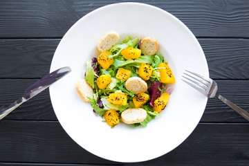 Delicious pumpkin salad with spices on black table, top view.