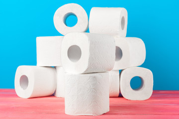 Toilet paper rolls stacked against blue background