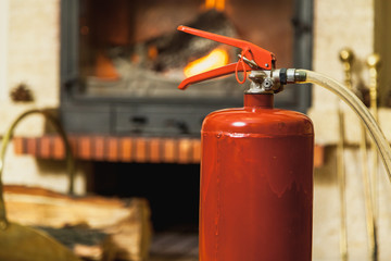 Fire and safety. Fire extinguisher stands in front of  fireplace