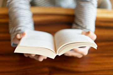 Hand holding a book at home