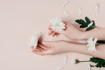 Creative image beautiful groomed woman's hands with white flowers with copy space on pink background in minimalist style. Concept template feminine blog, social media, beauty concept