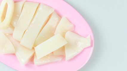 raw squid sliced on pink plate