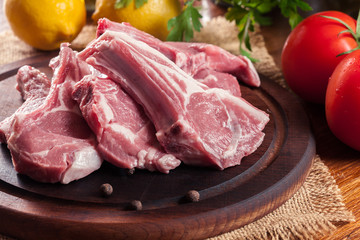 Raw fresh lamb chops on wooden cutting board