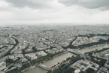 Obraz premium View of the city of Paris, France from top of Eiffel Tower on a cloudy day
