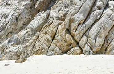 Weathered rock outcrop over fine sand beach of Thailand rocky island.