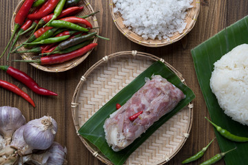 Sour Pork (Nham), a Thai northeastern style food made with mixed pork, rice, garlic, sugar and salt in banana leaf package, fermented-pork
