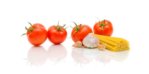 ripe tomatoes, pasta and garlic on a white background