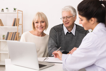Elderly couple discussing treatment plan with doctor