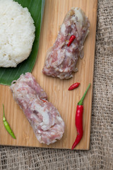 Sour Pork (Nham), a Thai northeastern style food made with mixed pork, rice, garlic, sugar and salt in banana leaf package, fermented-pork