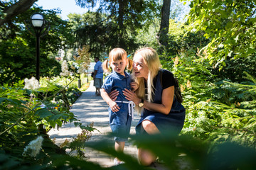 Cute blonde woman and her daughter in the park