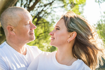 Adult couple loving each other in the Park on a Sunny day. Ordinary full man and full woman hug each other