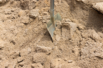 Fototapeta na wymiar Pile of sand and shovel for construction