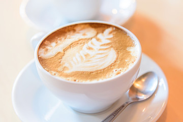 hot cappuccino with nice milk pattern on the table