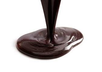 Pouring melted chocolate on white background