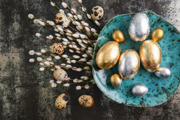 Obraz premium Plate with beautiful Easter eggs and pussy willow branches on dark background