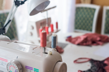 sewing machine with coils of coral thread . close-up threads.
