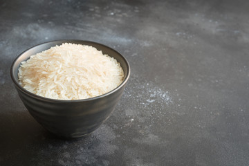 Steamed rice in bowl on black background. Copy space.