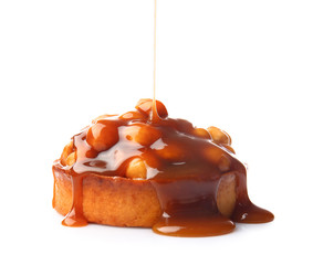 Liquid caramel pouring on cake against white background