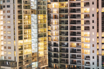 Central city property for rent and lease with apartment windows at night.  Real estate agent selling condos for housing in beautiful contemporary buildings.