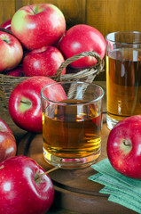 Apple juice in glasses and ripe apples.