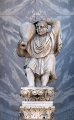 Obraz premium Sculpture of a man carrying a wine jug at St. Mark's Basilica, detail of the facade of the Saint Mark's Basilica, St. Mark's Square, Venice, Italy, UNESCO World Heritage Sites