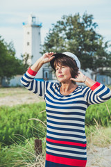 Fototapeta premium Elderly woman looking into the distance on seashore