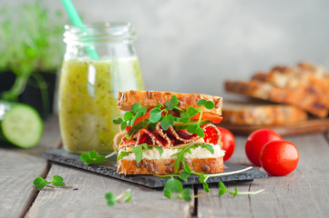 Homemade sandwich with radish sprouts on rustic wooden background