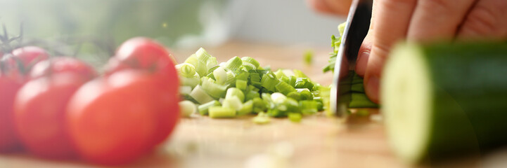 Cook holds knife in hand and cuts on cutting