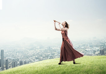 Girl playing her melody on fife at summer bright day