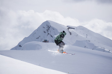 Flying skier on snowy mountains. Extreme winter sport, alpine ski.