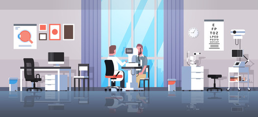 male ophthalmologist checking patient vision doctor in uniform making eye surgery laser correction medicine and healthcare concept oculists office interior horizontal