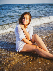 Fototapeta na wymiar Simple tan arabic girl from small town, plus size young lady at nature. Portrait of voluptuous young woman posing sensually on ocean background 