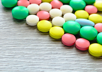 A lot of multi-colored tablets of different shapes. Pills are used in medicine to heal people.