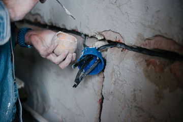 Worker inserts an electrical outlet box