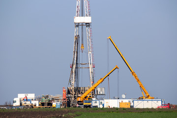 land oil drilling rig and cranes on oilfield mining industry