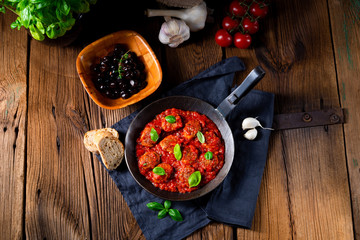 Baked mini meatballs in tomato sauce with basil