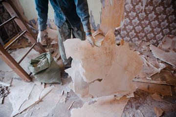 Worker cleans the trash in the apartment in the bag