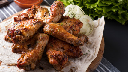 Roasted chicken wings with red sauce. Copy space