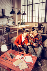 Two guitar players playing the music in their spacious apartment
