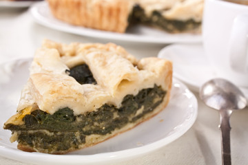 piece of cheese and spinach pie on white plate