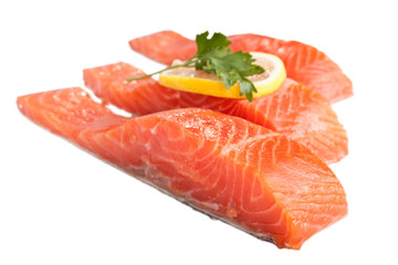three fresh salmon steaks with lemon isolated on white