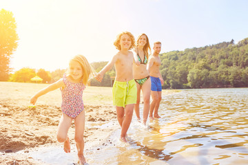 Familie mit Kindern beim Baden am See im Sommer